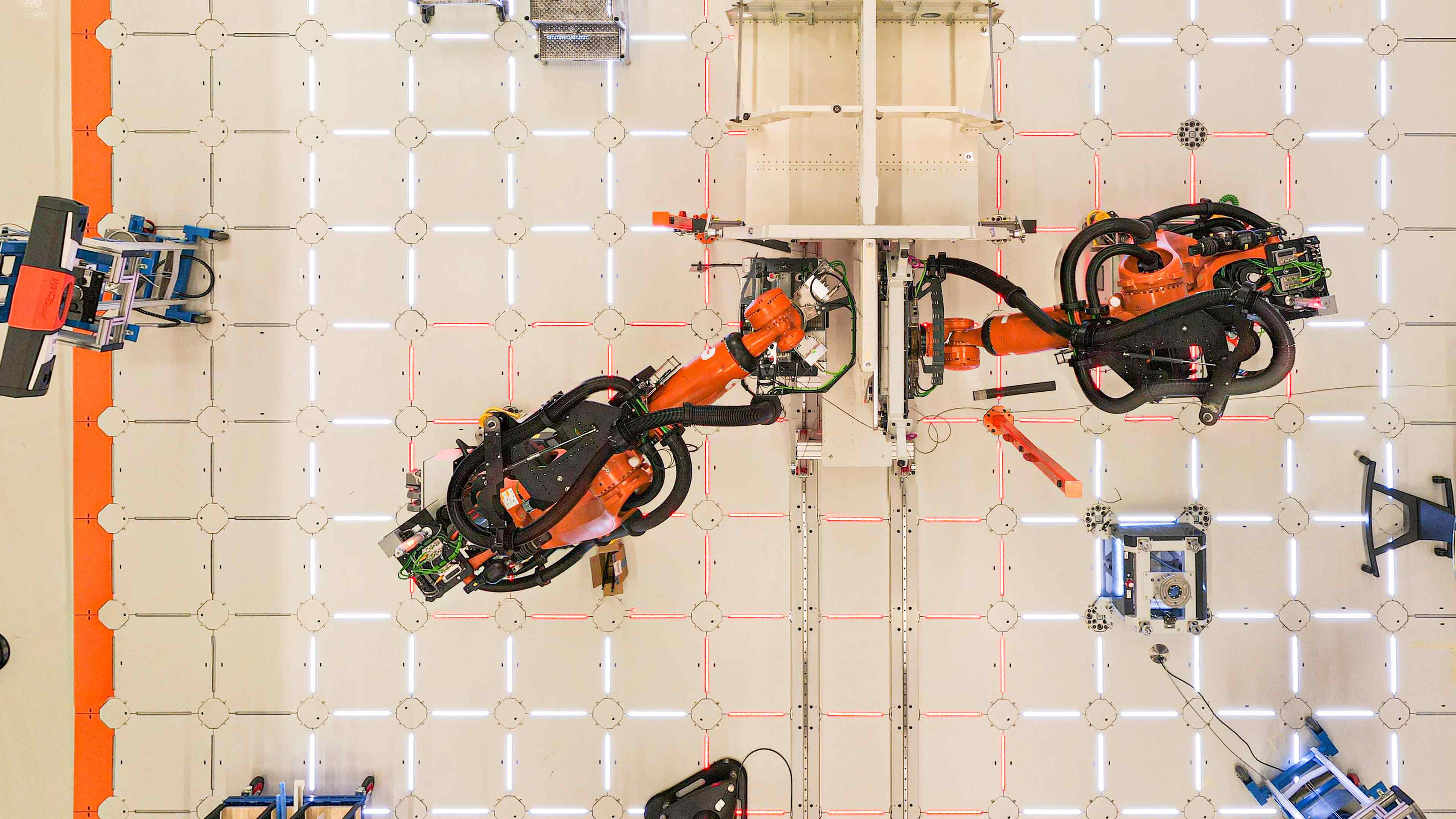 Industrial robots positioned around a large aerospace structure